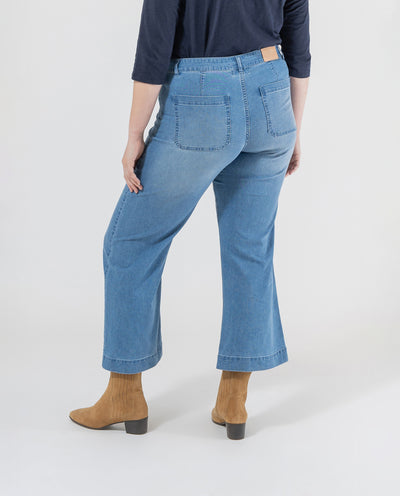 PANTALÓN DENIM CON BOLSILLOS PLASTRON Y BAJO EVASE AZUL MEDIO